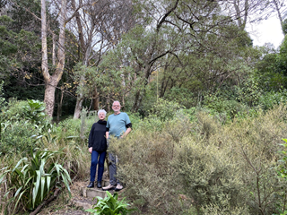 Man and woman standing side by side in a garden.