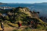 People walking along a pathway overlooking water.