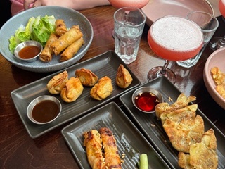 Food at a restaurant with cockatils on the table.