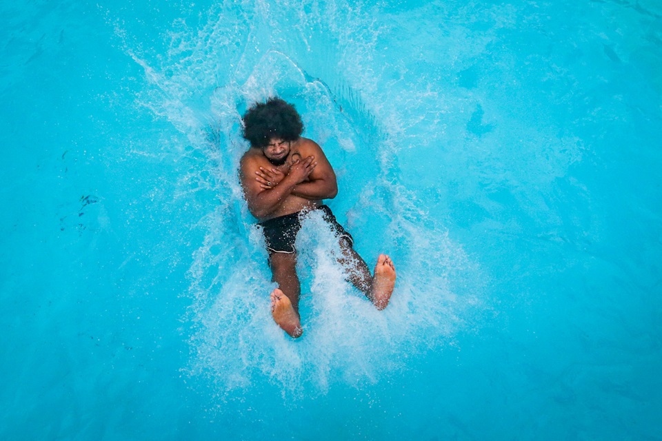 Birdseye view of person doing manu and landing with big splash in water