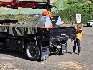 A man in high vis standing next to a truck.