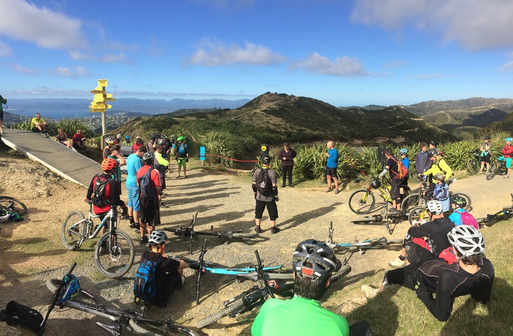 Group of bike riders in a circle on top of Makara Peak.