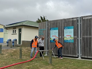 Three men in the middle of training, learning how to manage a water distribution point.