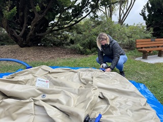 Woman crouching down to fix a water bladder.