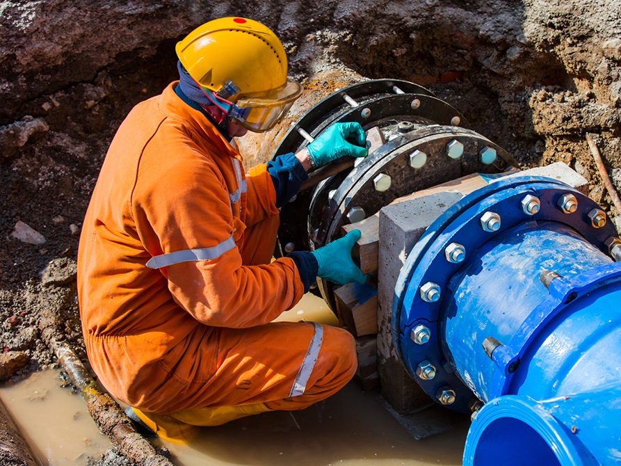 Construction worker doing a job with pipes.