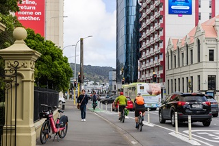 Person walking down the road with cars on the street