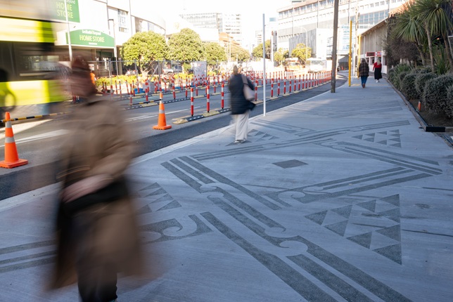 Person walking along the pavements infront of Thorndon Quay.