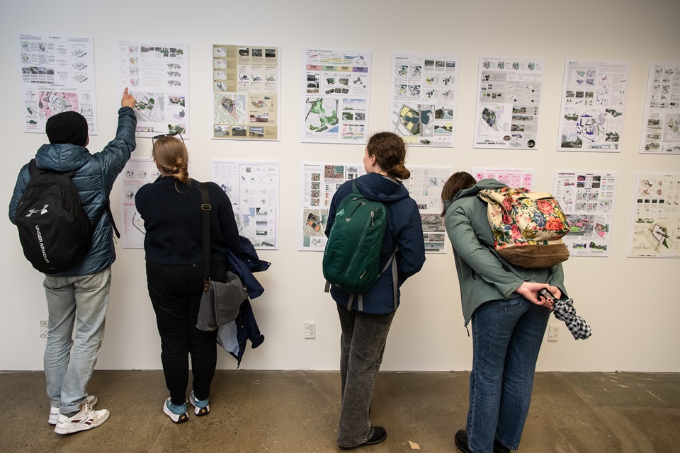 Te Ngākau exhibition people viewing work on wall of displays.