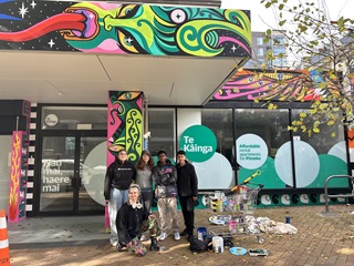 Xoë Hall and the rangatahi advisory group in front of the Te Tai Ohinga Mural