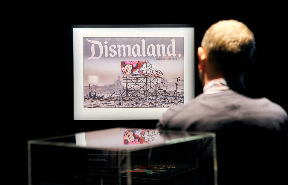 Man looks at Dismaland Banksy artwork at exhibition