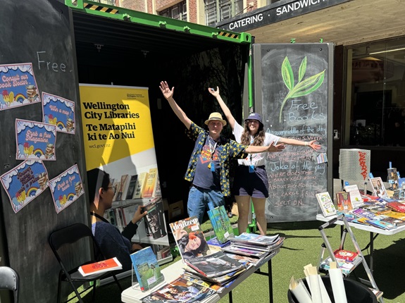 Two people standing infront of a book pop up.