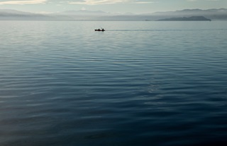 Close up of water in the harbour with hills in the background.