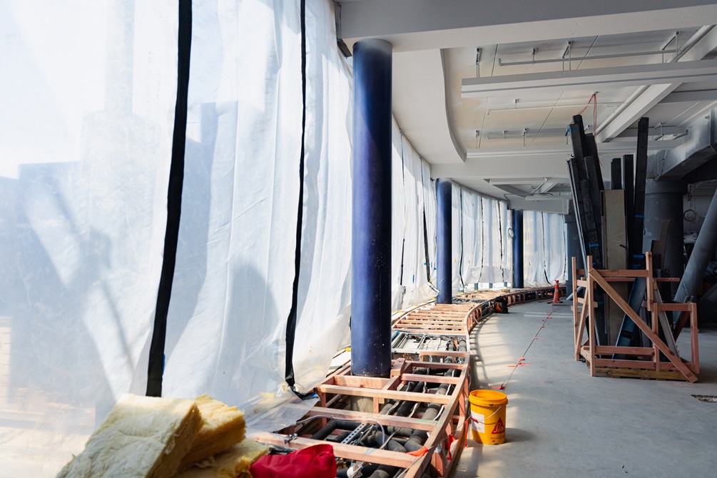 The inside of a building under construction with sheets on the side.