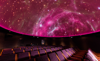 Planetarium dome at Space Place lit up with pink lights.