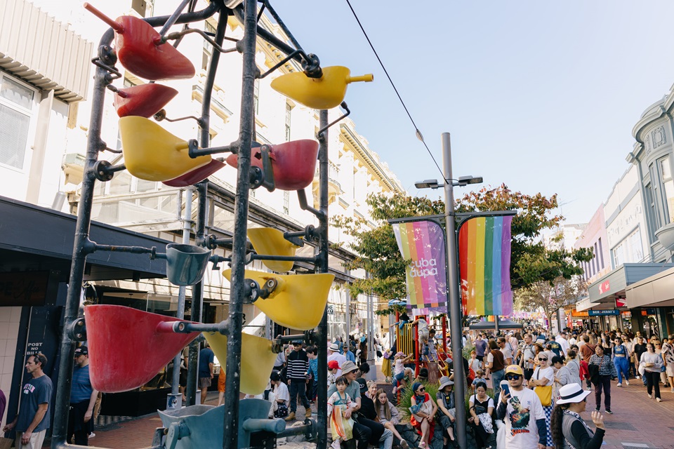 Bucket fountain with people in the background walking down the street.
