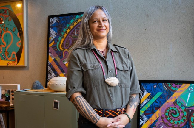 Jaime Berry sitting in front of an artwork.