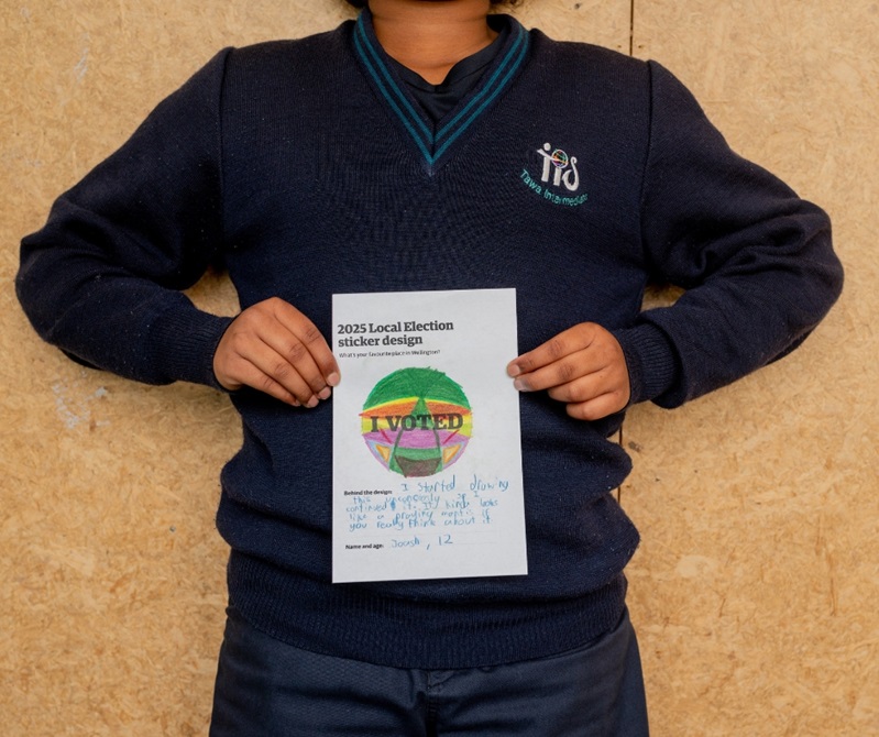 A kid holding their drawing