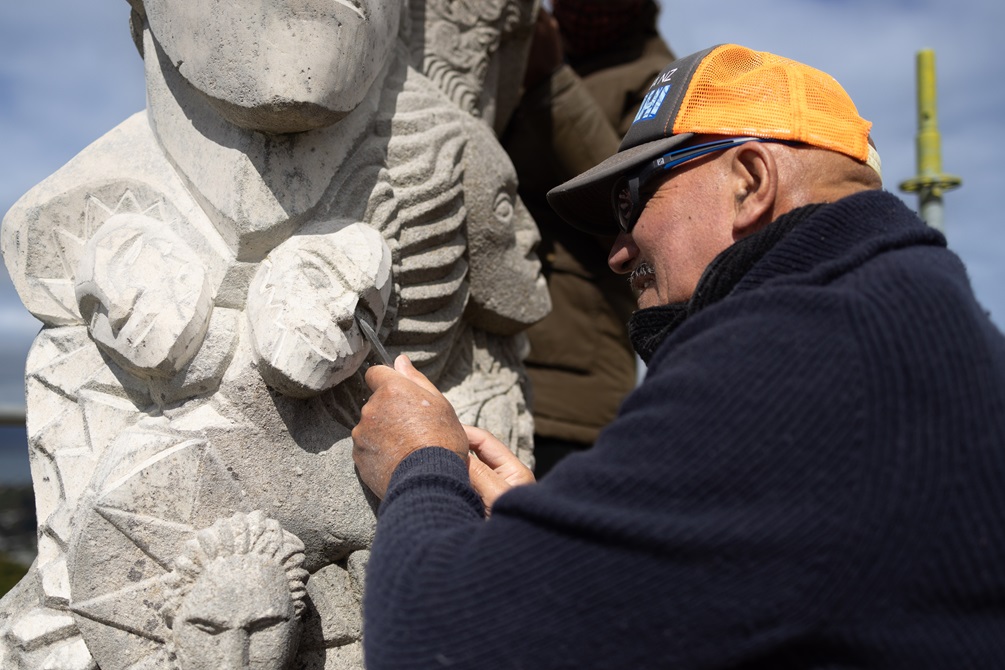 Close-up of Matahi carving into the side of the pou
