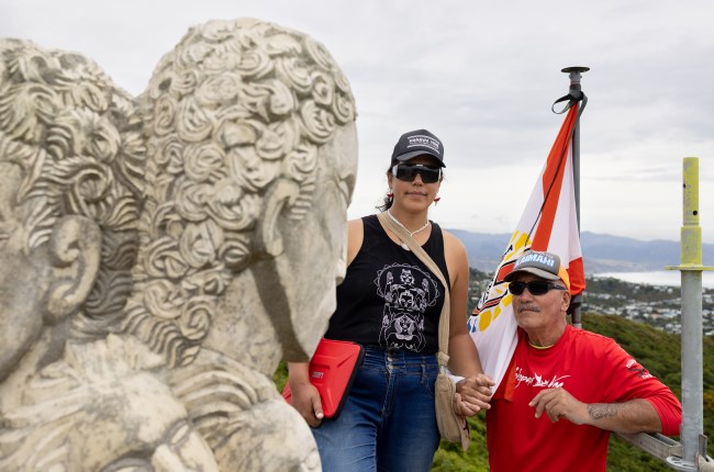 Ariki and Matahi standing next to the pouwhenua 