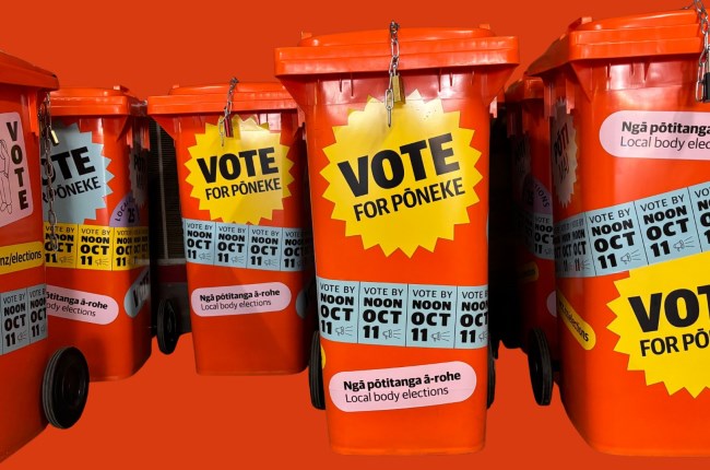 Orange voting bins with stickers plastered all over with details about voting