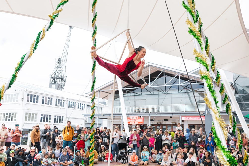 A circus performer doing aerial acrobatics in front of a crowd.