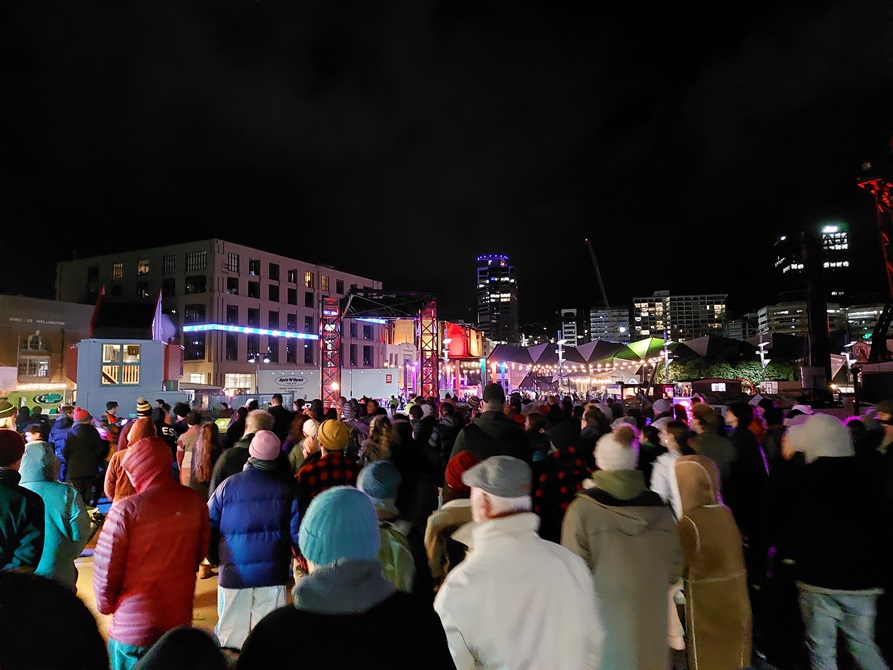 A crowd of people moving across the Wellington Waterfront.