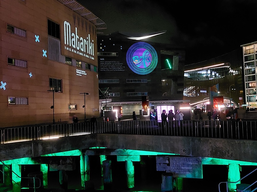 Te Papa museum lit up with colourful designs and text reading 'Matariki'.