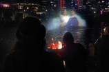 Onlookers in the foreground watch a short film projected on a fountain in the middle of Whairepo Lagoon.