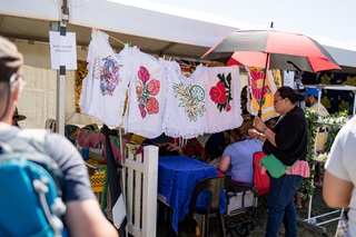 Woman looking at a stall for a Niue carving workshop at Pasifika Festival