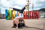 Street performers in front of Wellington sign on the waterfront.