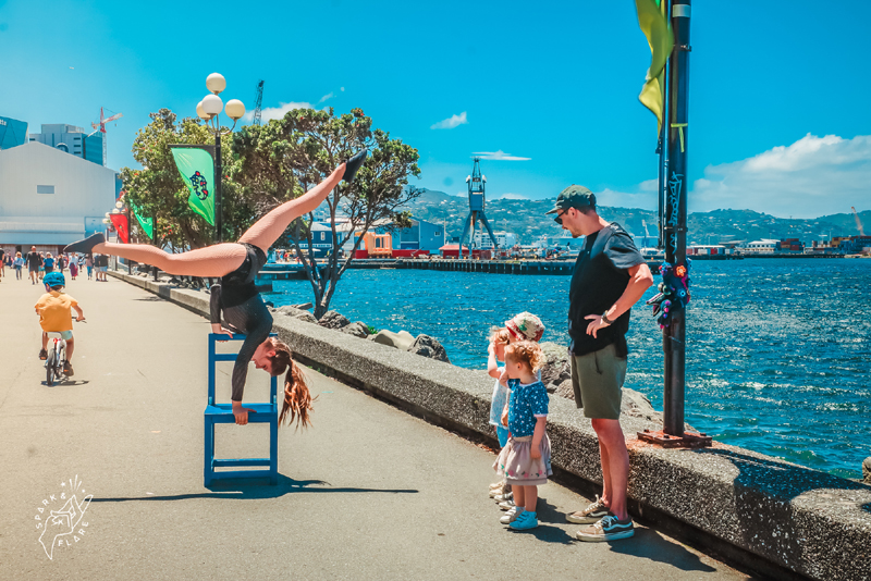 Family watching a street performer along the waterfront.