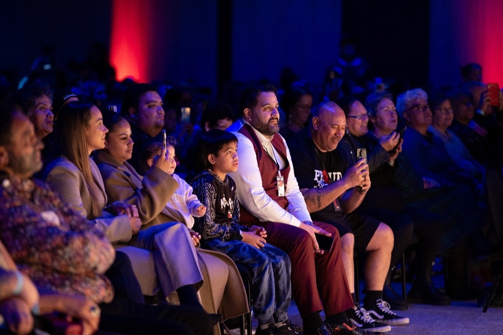 A seated crowd of onlookers enjoying a performance by Stan Walker.