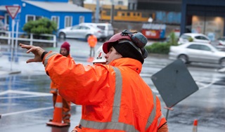 Roadworker at intersection pointing.