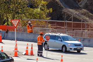 Car stopped at intersection by roadworker.