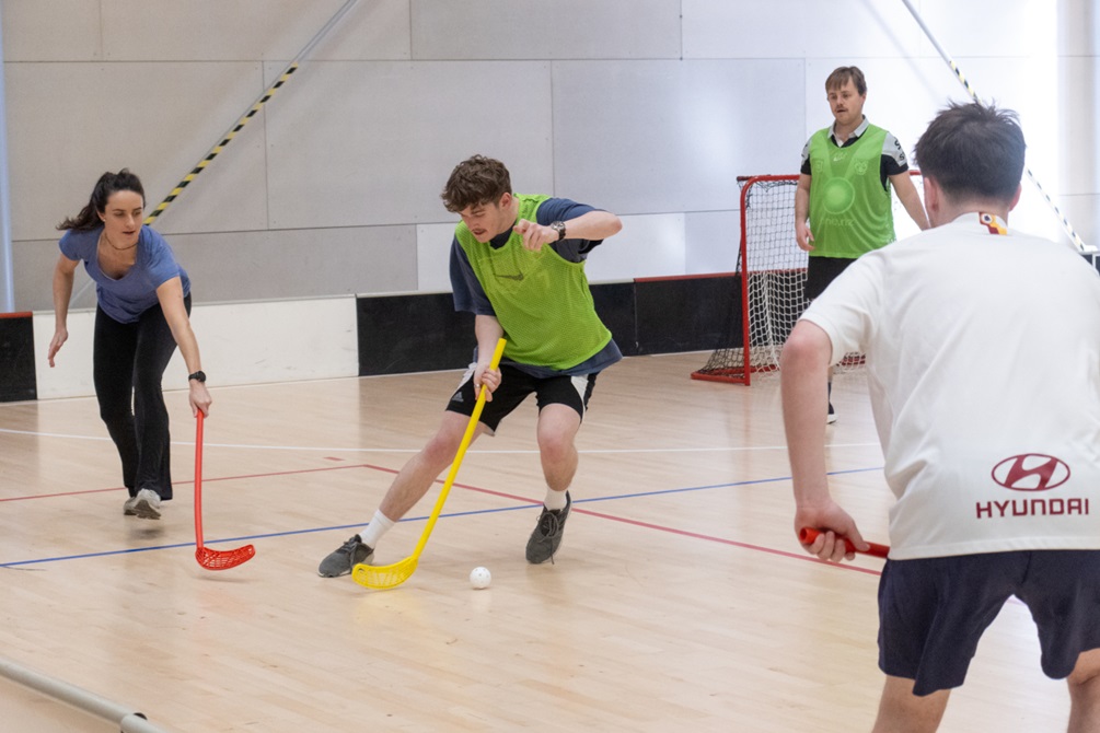 People playing hockey indoors.