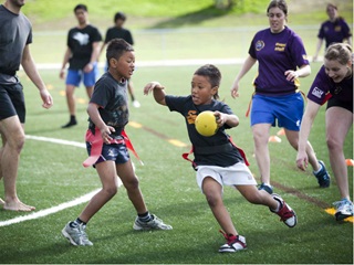 Children playing ki o rahi on an artificial sportsfield.