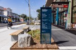 Island Bay shopping centre showing a footpath, seating area, bike lane and signage.