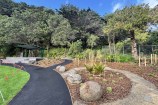 View of a planted garden and tiered seating area in the corner of the park.