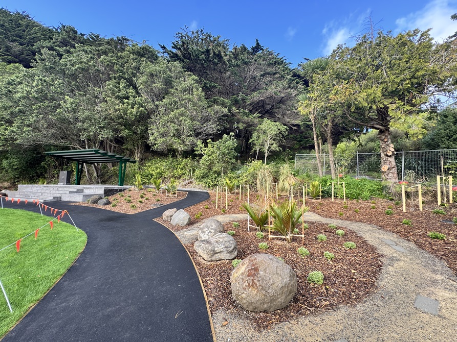 View of a planted garden and tiered seating area in the corner of the park.