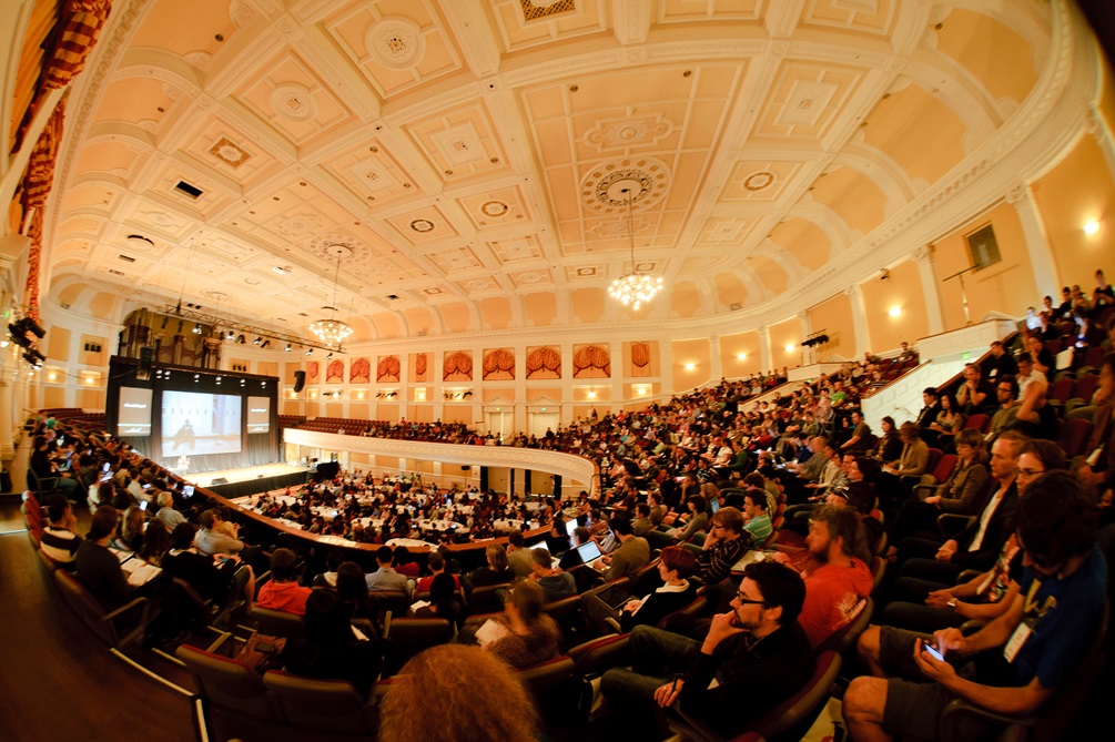 Pressed tin ceiling above a packed auditorim in the Town Hall.