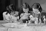 Three girls look at missionary exhibits at the Town Hall in 1951.